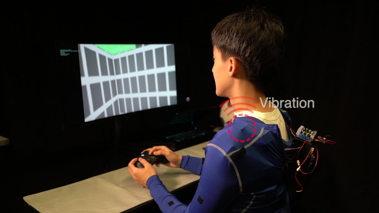 A participant with the suit, a red circle marking the vibrating shoulder unit
