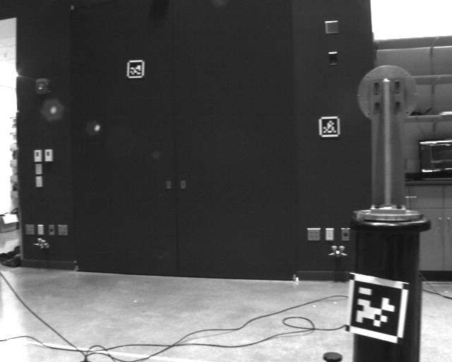 Motion-capture room with AprilTags on a dark wall